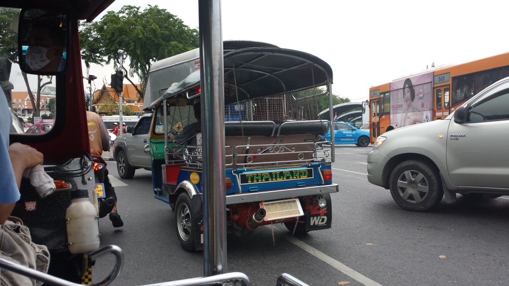 En lille tuktuk i trafikkaos.